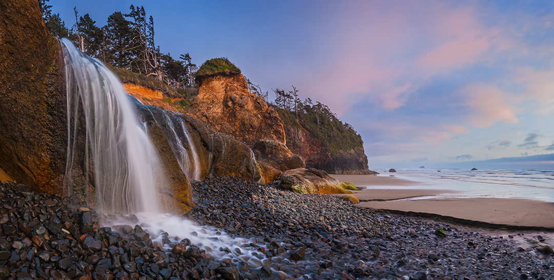 Photo a waterfall crashing onto the beach at Hug Point on the Oregon coast.